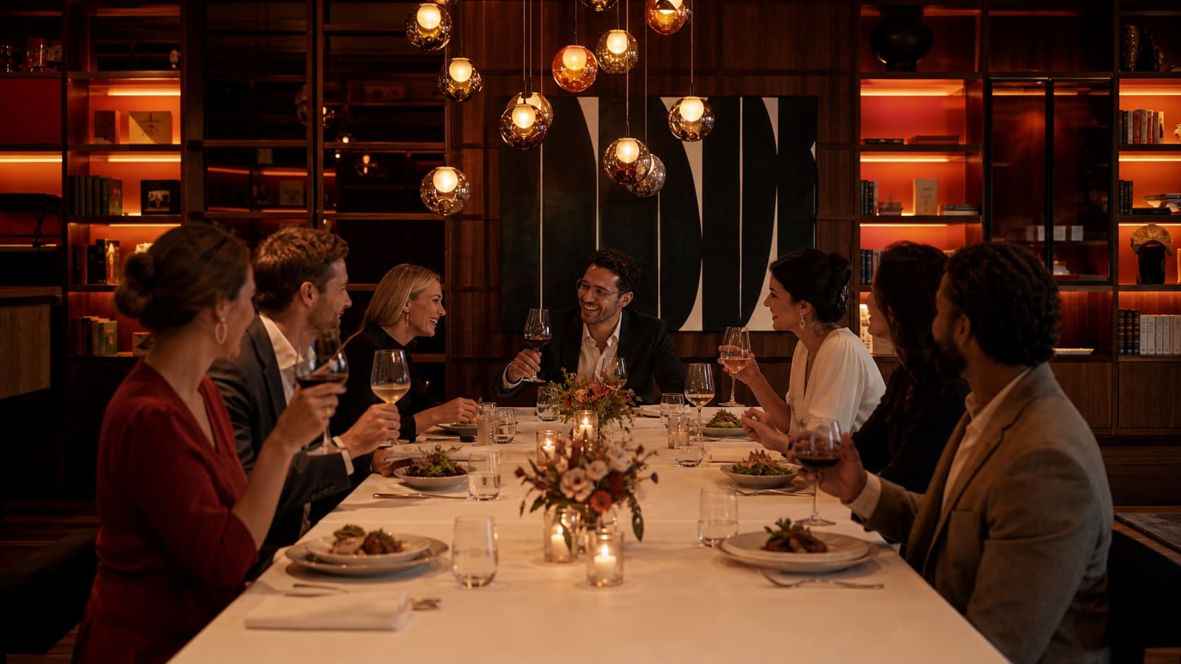 Guests dining at an event in a warmly lit private venue